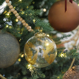 Exquisite 3" Artisan Glass Gold Etched Leaf Ornament by CG Hunter, featuring hand-painted gold etchings, beautifully displayed on a festive Christmas tree with warm lighting.