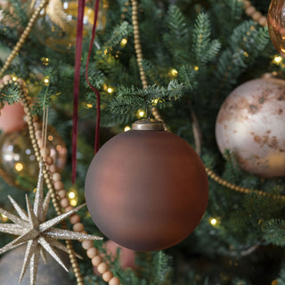 Charming 3" Frosted Cinnamon Glass Ornament by CG Hunter, artfully positioned among Christmas tree ornaments, exuding warmth and holiday spirit.
