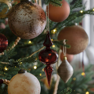 Artistic display of a 5" Mercury Marble Glass Ornament by CG Hunter alongside elegant glass ornaments, enhancing the festive ambiance of a Christmas tree.