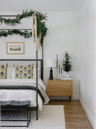 Luxurious bedroom showcasing the 24" / 2’ Artificial Evergreen Cedar Tree Set by CG Hunter, harmoniously integrated into a sophisticated decor with canopy bed and festive greenery.