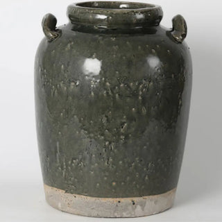 Green ceramic jar with two handles on a white background