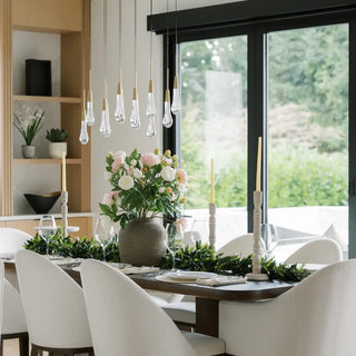 Dining room with a table set for a meal, featuring flowers and candles.