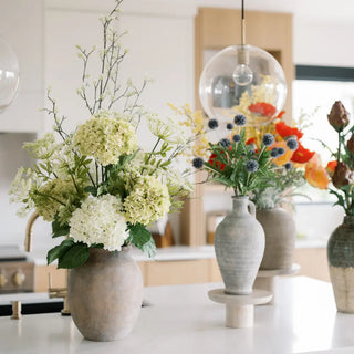Decorative vases with flowers on a kitchen counter