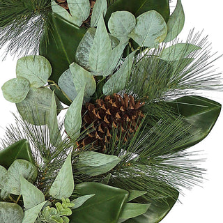 Close-up view of the 28" Magnolia, Eucalyptus, Pinecone, & Needle Pine Wreath by CG Hunter, highlighting the intricate details of eucalyptus leaves, pinecones, and wisps of needle pine for a luxurious seasonal touch.