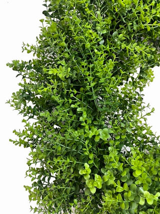Close-up of a green artificial bush on a white background