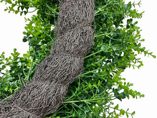 Ball of twine wrapped in string with green foliage on a white background