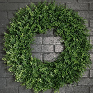 Green wreath on a brick wall