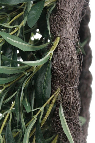 Close-up of a decorative wreath with green leaves and brown twigs on a white background