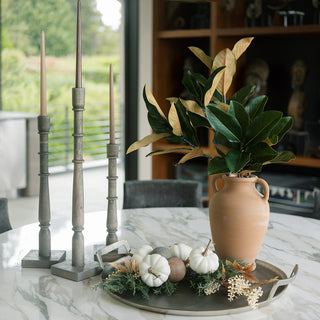 Elegant display of the 36" Faux Green Magnolia Leaf Stem by CG Hunter in a stylish vase, surrounded by decorative elements, perfect for enhancing seasonal decor aesthetics.
