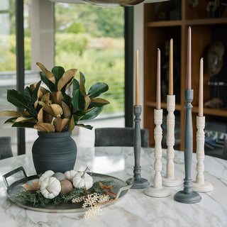 Elegantly styled tabletop featuring a CG Hunter 36" Faux Green Magnolia Leaf Stem in a chic arrangement with sophisticated candle holders and rustic decorative pumpkins, perfect for seasonal decor.
