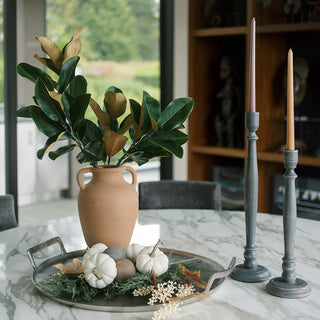 Elegant arrangement featuring CG Hunter's tapered candle holder in dark grey wood, surrounded by a stylish vase with foliage, delicate pumpkins, and a decorative tray, showcasing a luxurious home decor aesthetic.