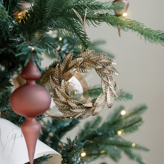 A luxurious 8-Piece Brass Wreath Ornament Set by CG Hunter, featuring a handcrafted brass ornament shaped like a delicate leaf wreath, elegantly displayed on a beautifully decorated Christmas tree.