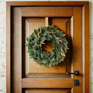 Elegant 30" Faux Green Magnolia Leaf Wreath by CG Hunter displayed on a wooden door, showcasing vibrant leaves for luxurious seasonal decor.