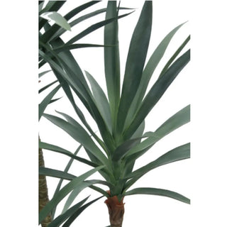 Artificial yucca plant with long green leaves on a white background
