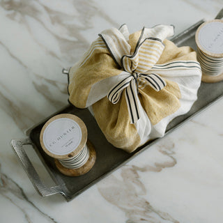 Grosgrain Ribbon in Cream and Black 10 Yards Per Spool by CG Hunter adorning a stylish linen pouch on a sleek tray, embodying a blend of modern luxury and classic charm.